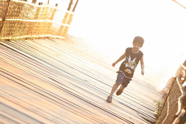 橋を走って渡る少年