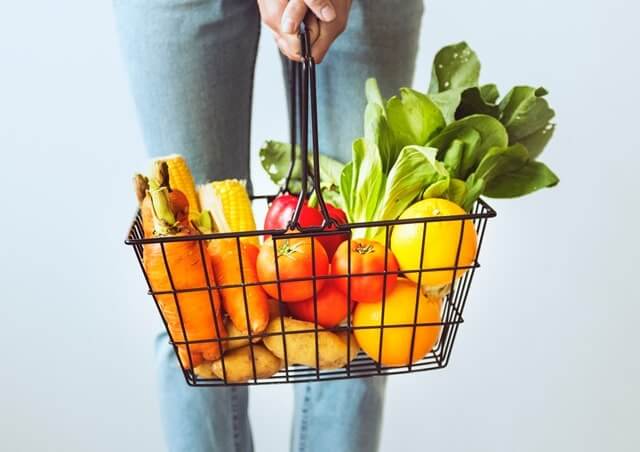 野菜の入ったカゴを持つ女性